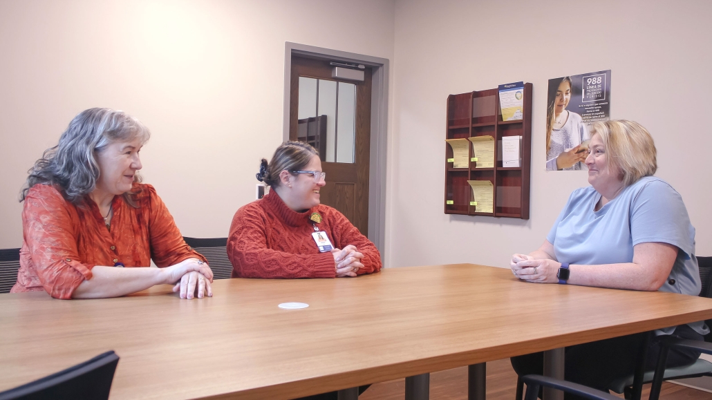 Three people sitting at table smiling