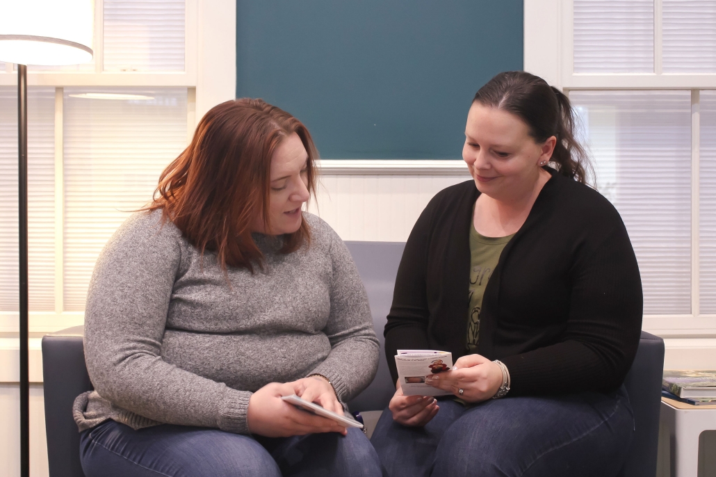 Two people sitting and looking at brochures