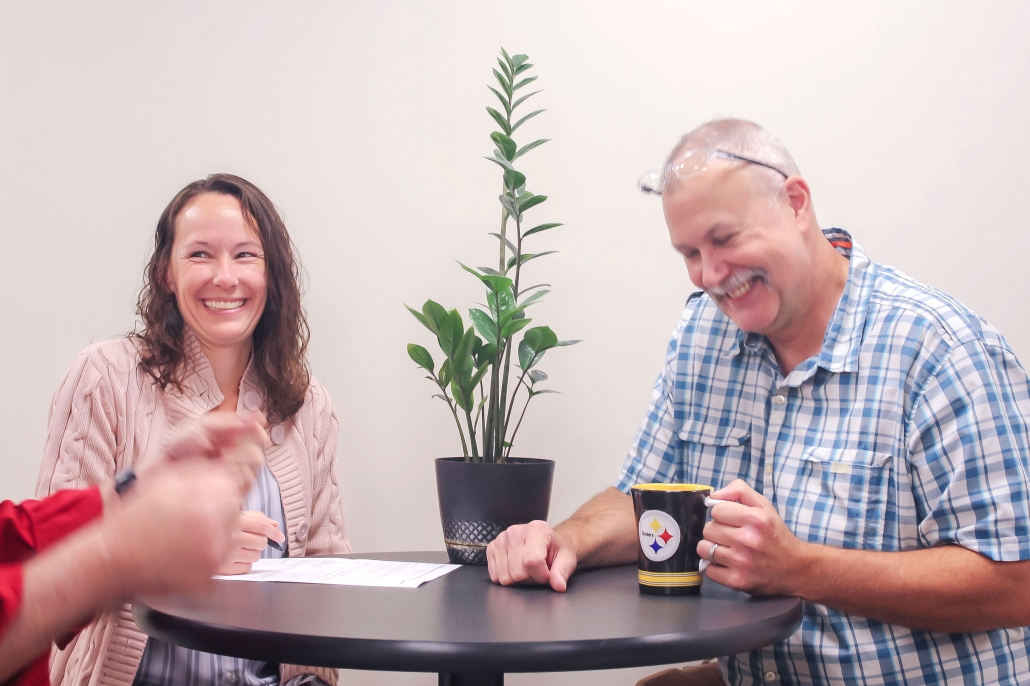 Two people sitting at table smiling/laughing